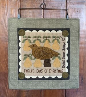 Partidge quilt hanging on a quilt hanger